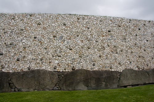 Close view of reconstructed wall, with original stones along bottom